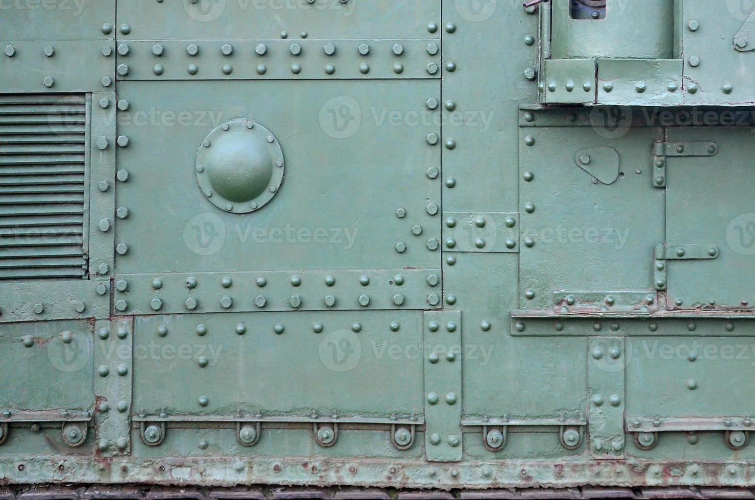 Texture of tank side wall, made of metal and reinforced with a multitude of bolts and rivets photo