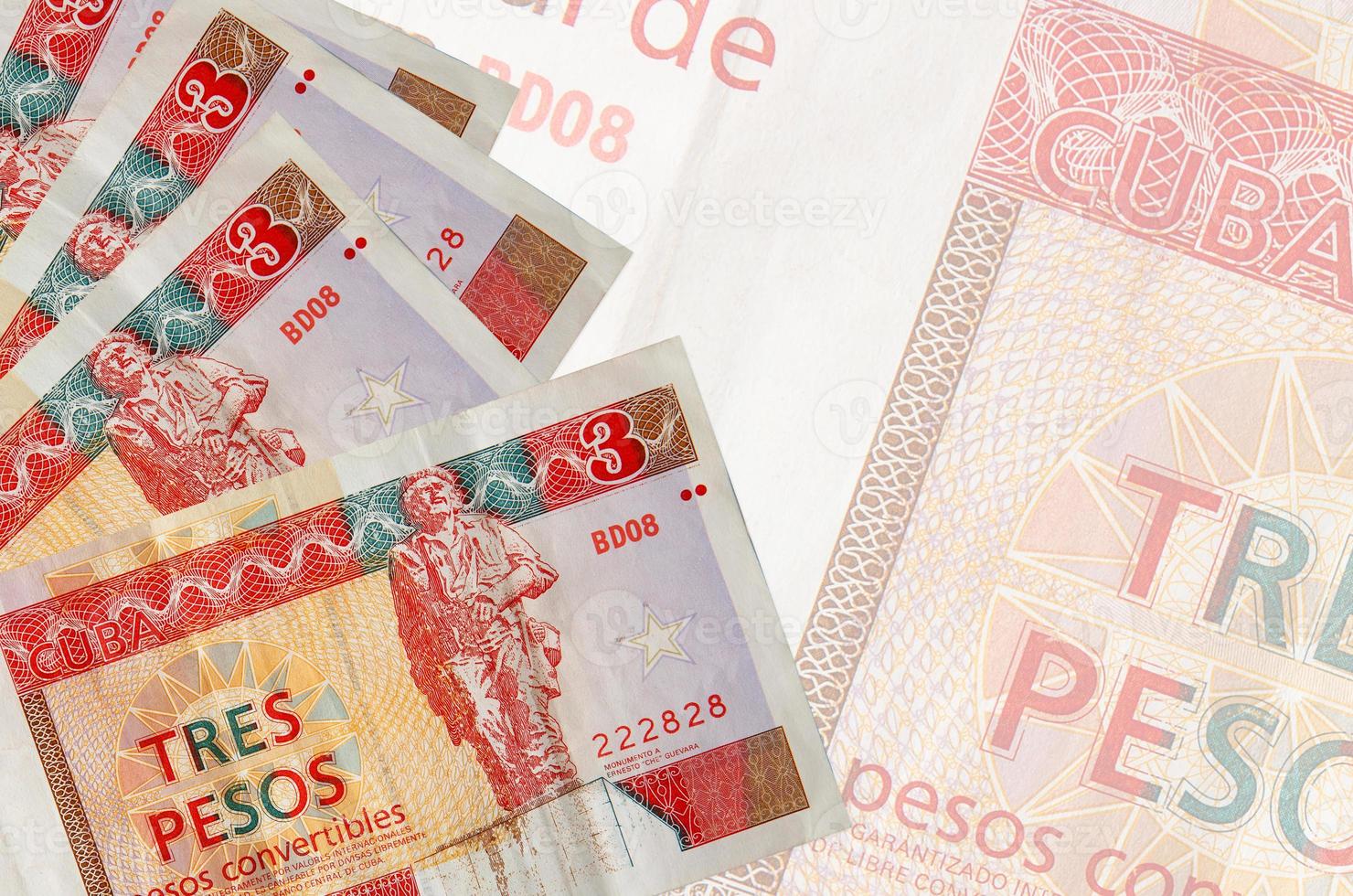 Los billetes convertibles de 3 pesos cubanos se encuentran apilados sobre el fondo de un gran billete semitransparente. fondo de negocios abstracto foto