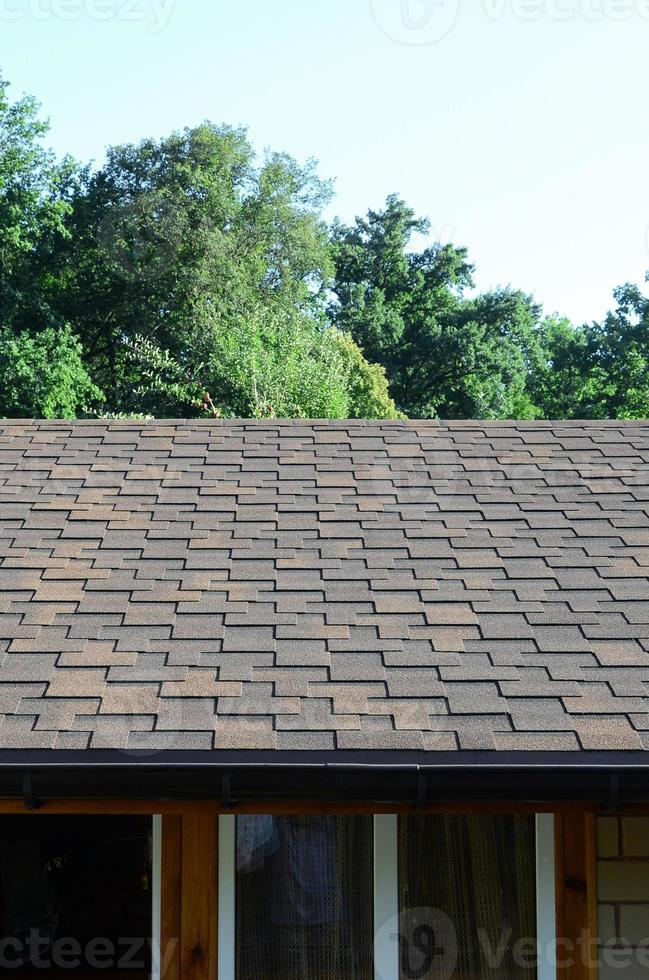Modern roofing and decoration of chimneys. Flexible bitumen or slate shingles photo