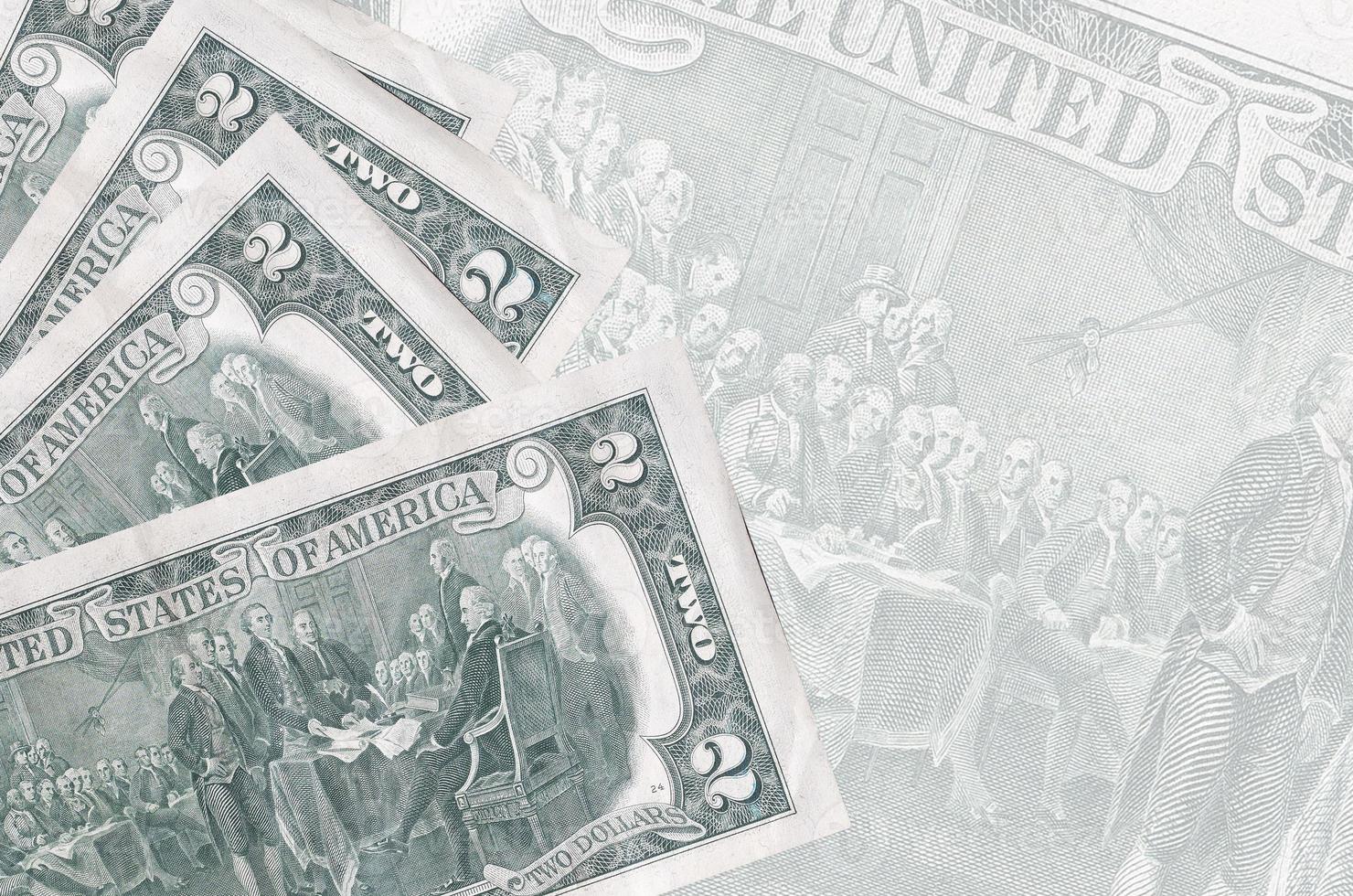 2 US dollars bills lies in stack on background of big semi-transparent banknote. Abstract business background photo