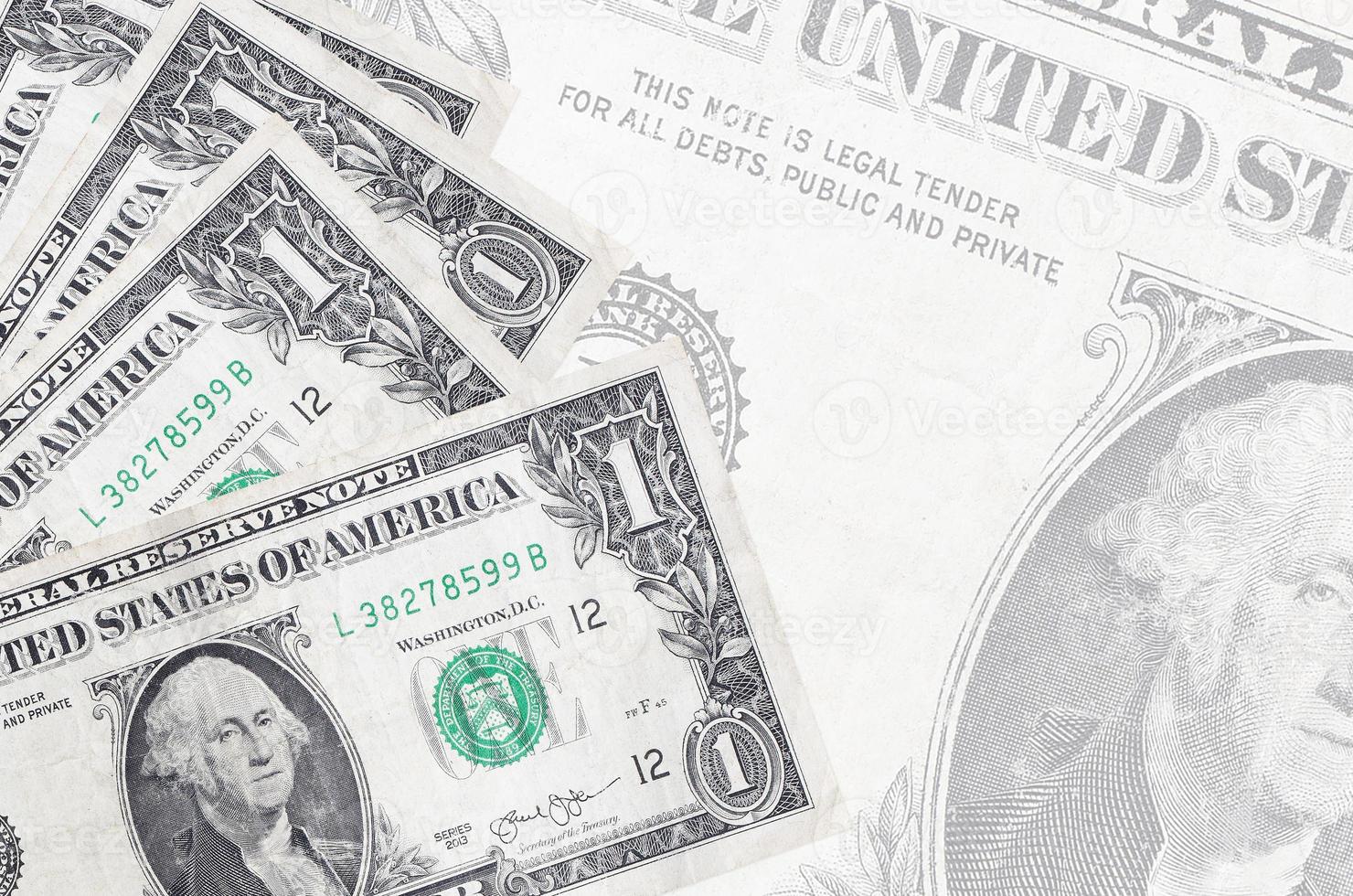 1 US dollar bills lies in stack on background of big semi-transparent banknote. Abstract business background photo