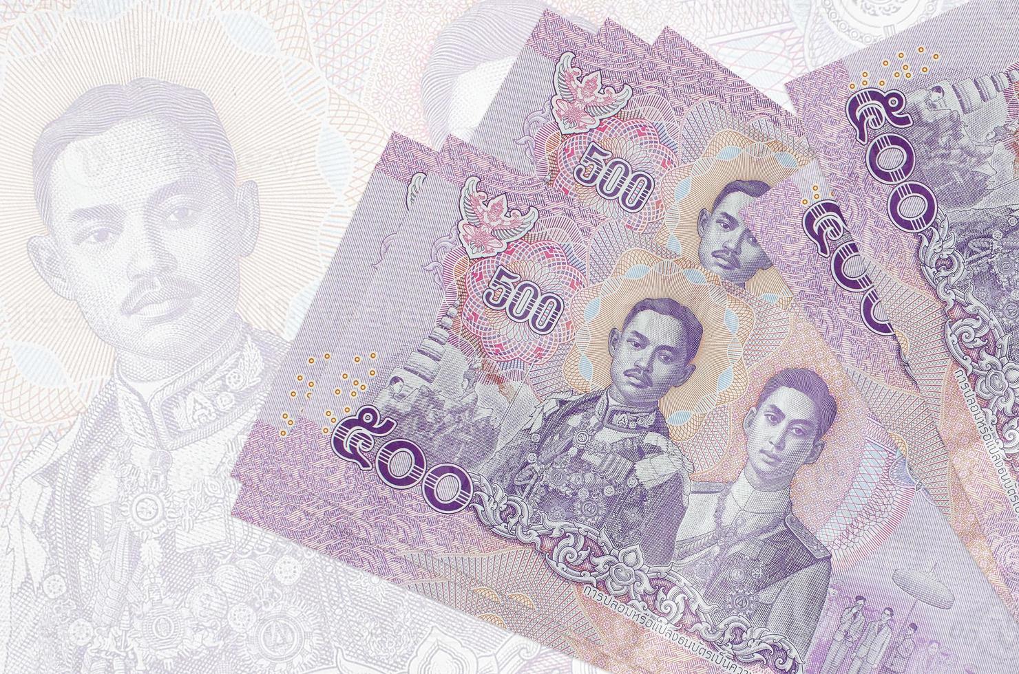 500 Thai baht bills lies in stack on background of big semi-transparent banknote. Abstract presentation of national currency photo