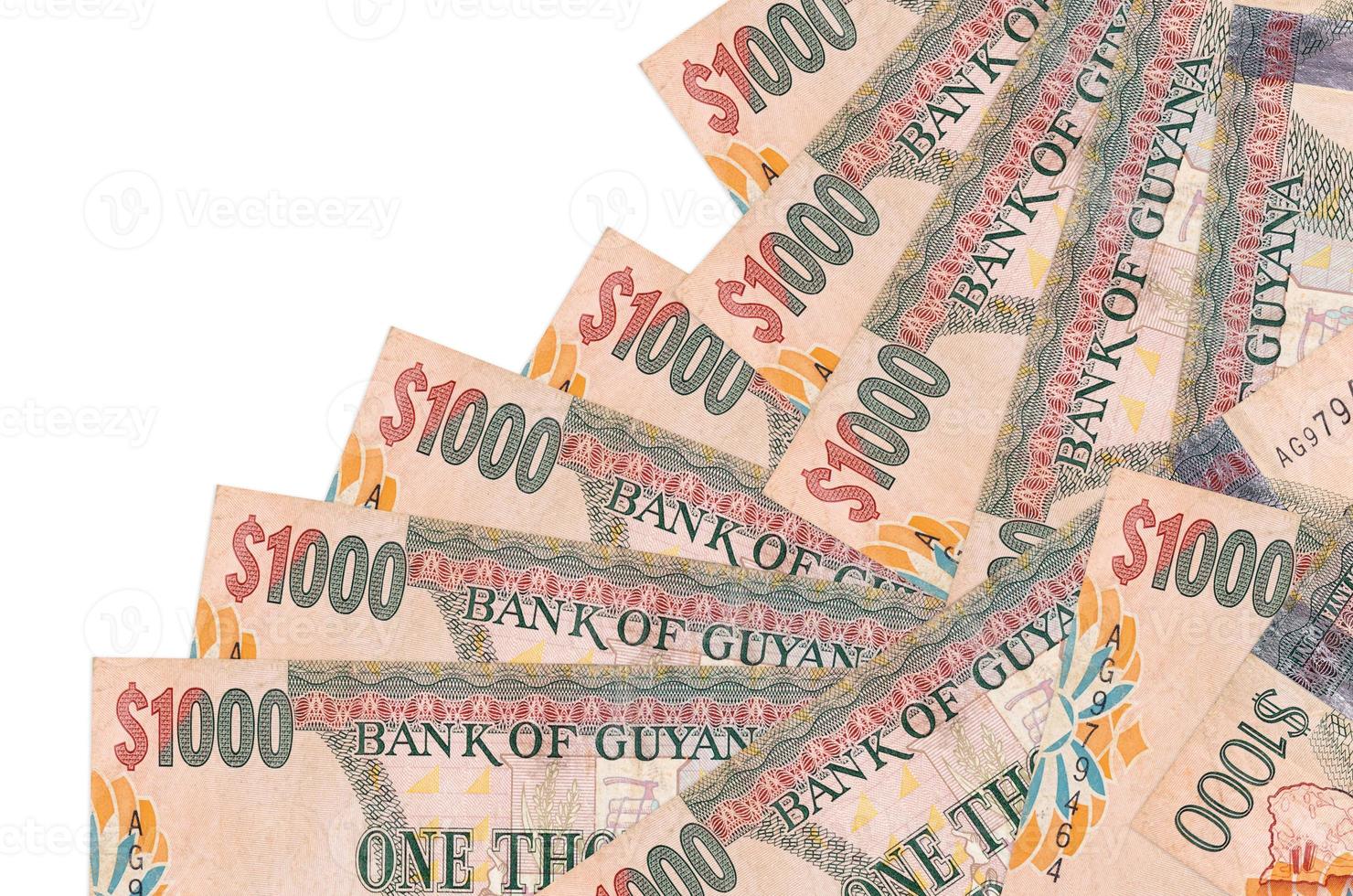 1000 Guyanese dollars bills lies in different order isolated on white. Local banking or money making concept photo