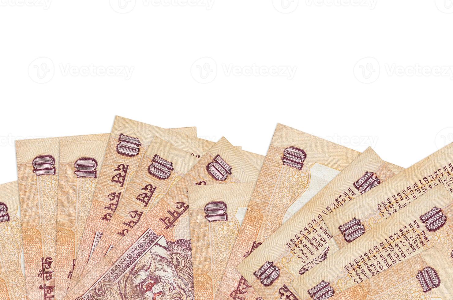 Los billetes de 10 rupias indias se encuentran en la parte inferior de la pantalla, aislados en fondo blanco con espacio de copia. plantilla de banner de fondo foto