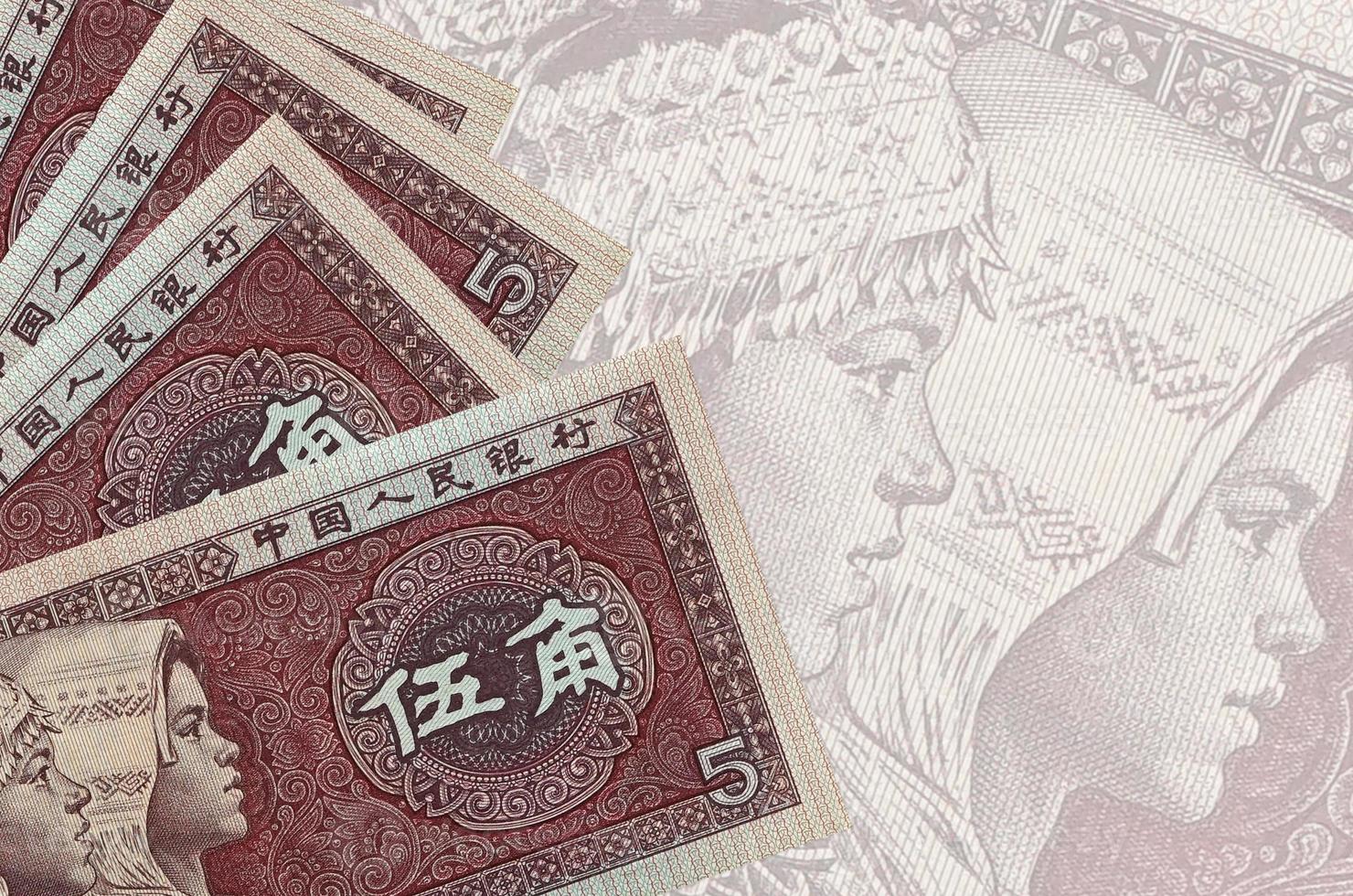 5 Chinese yuan bills lies in stack on background of big semi-transparent banknote. Abstract business background photo