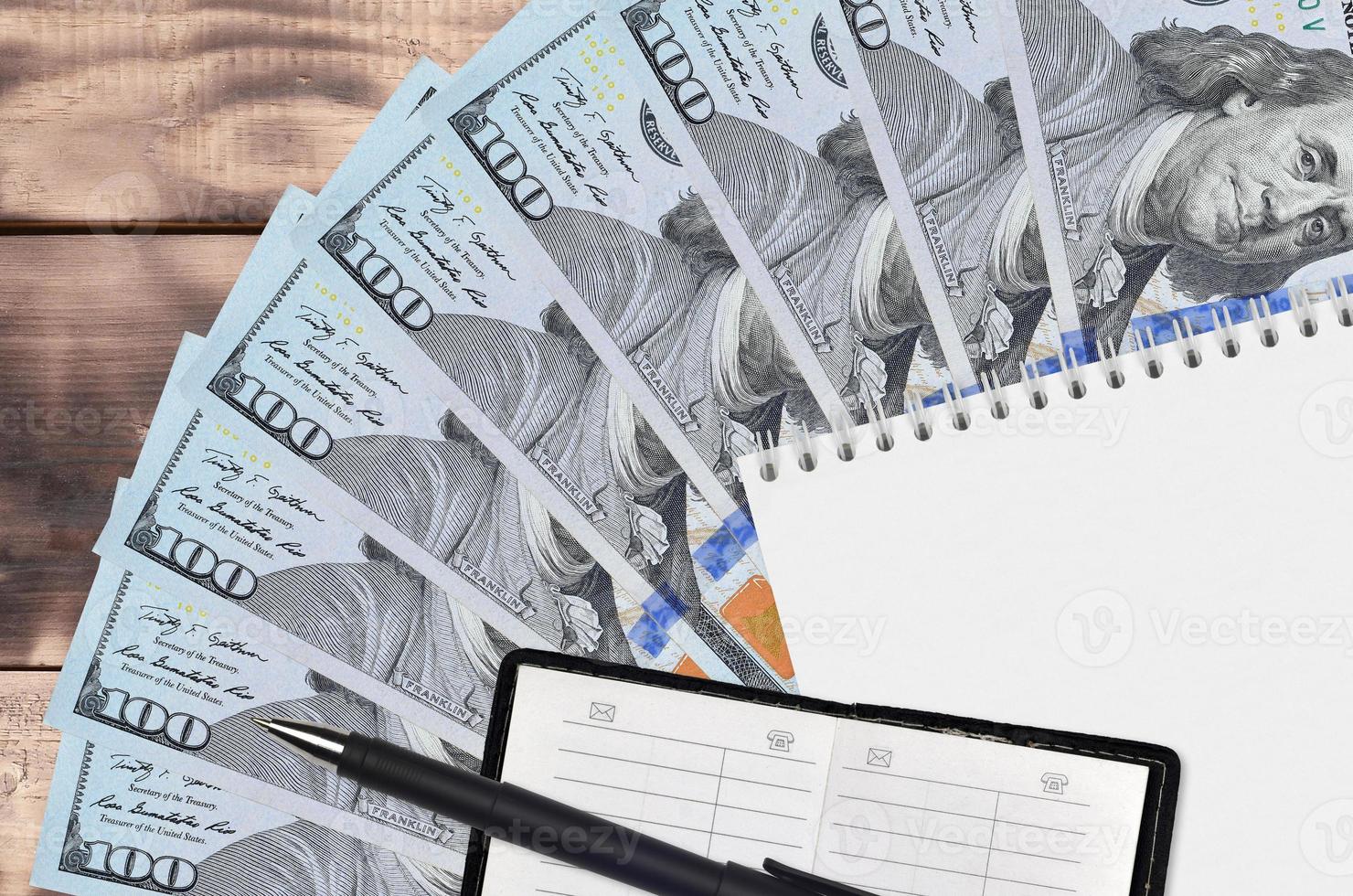 100 US dollars bills fan and notepad with contact book and black pen. Concept of financial planning and business strategy photo