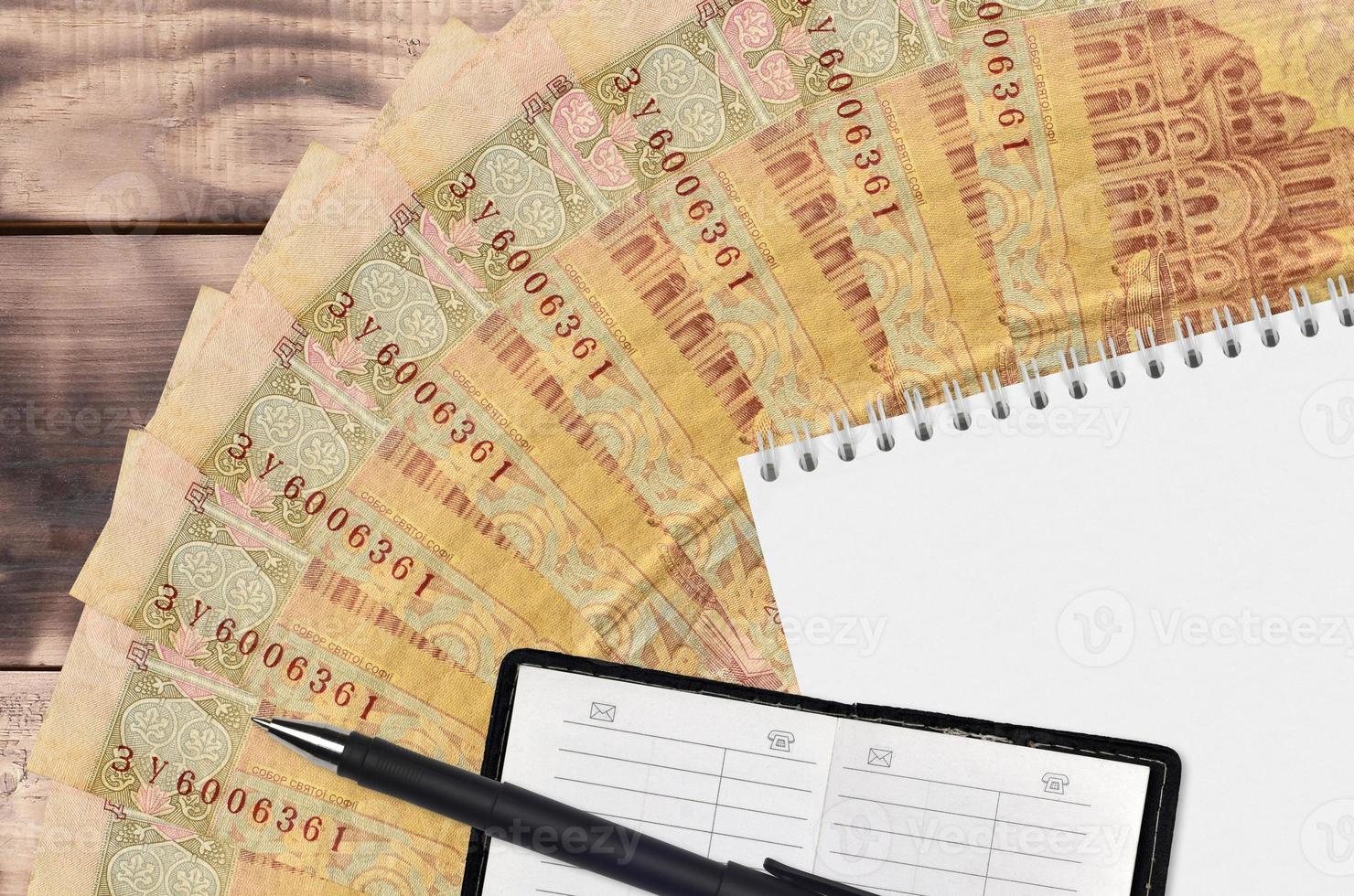 2 Ukrainian hryvnias bills fan and notepad with contact book and black pen. Concept of financial planning and business strategy photo