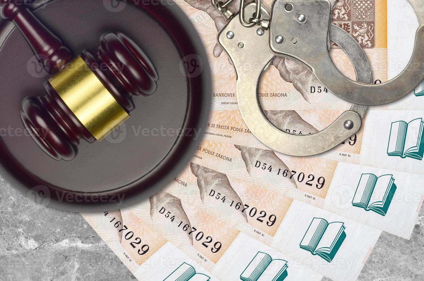 200 Czech korun bills and judge hammer with police handcuffs on court desk. Concept of judicial trial or bribery. Tax avoidance photo