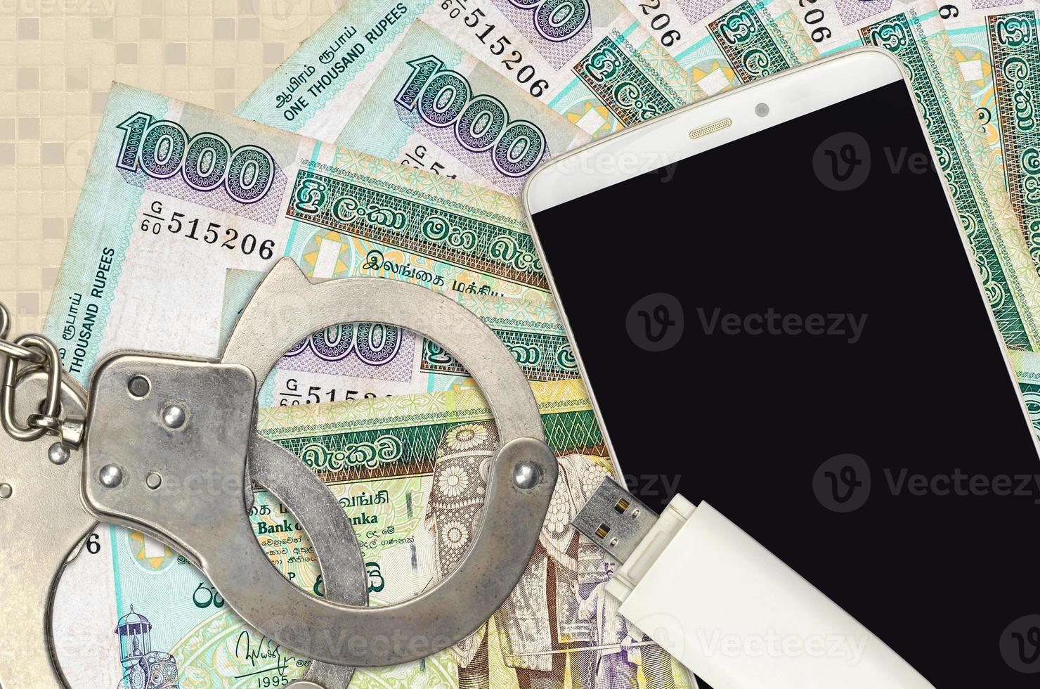 1000 Sri Lankan rupees bills and smartphone with police handcuffs. Concept of hackers phishing attacks, illegal scam or malware soft distribution photo