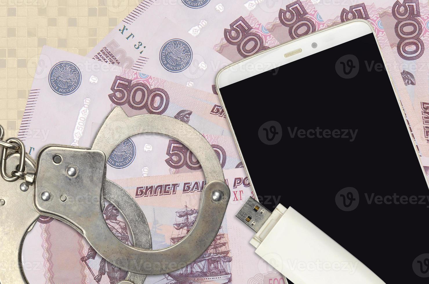 500 russian rubles bills and smartphone with police handcuffs. Concept of hackers phishing attacks, illegal scam or malware soft distribution photo