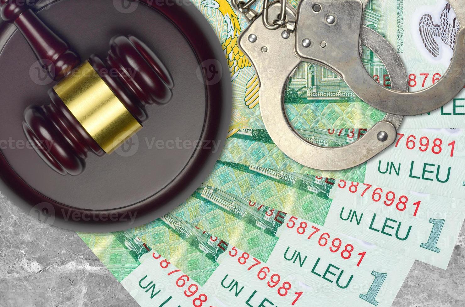 1 Romanian leu bills and judge hammer with police handcuffs on court desk. Concept of judicial trial or bribery. Tax avoidance photo