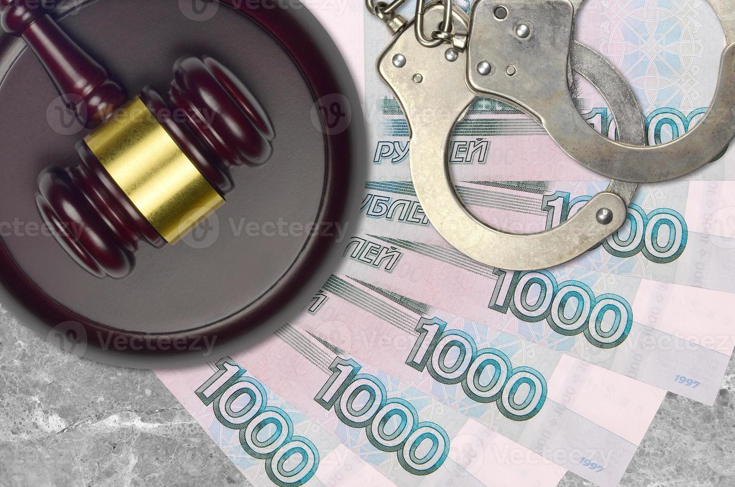 1000 russian rubles bills and judge hammer with police handcuffs on court desk. Concept of judicial trial or bribery. Tax avoidance photo