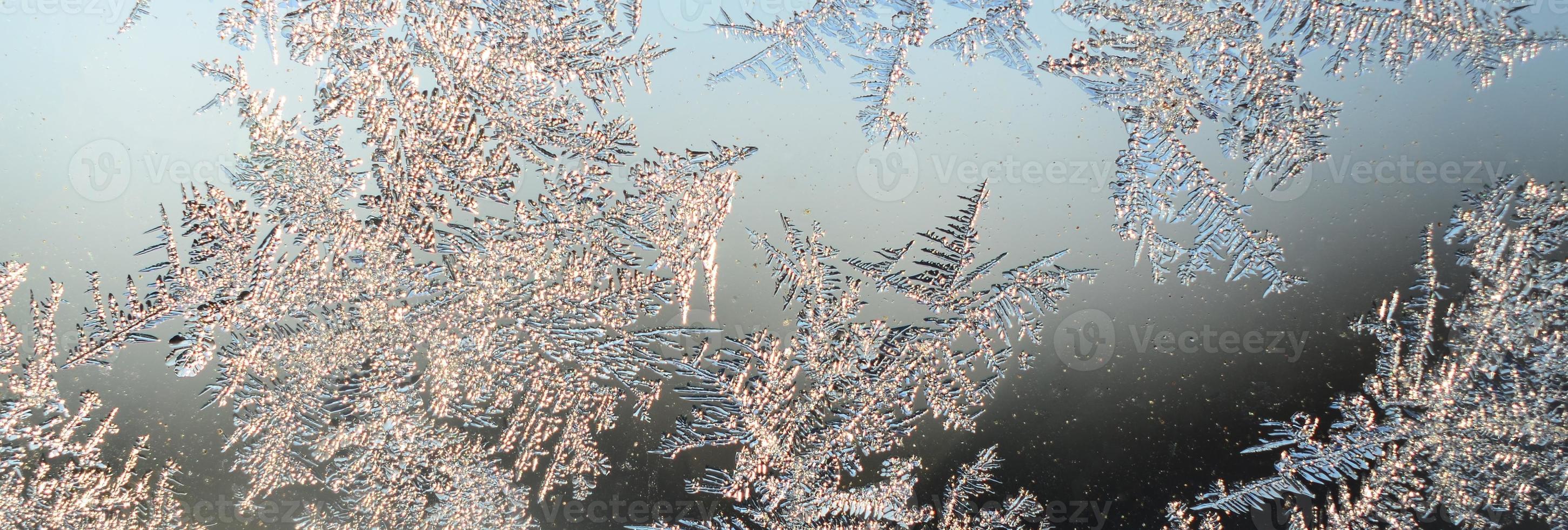 Snowflakes frost rime macro on window glass pane photo