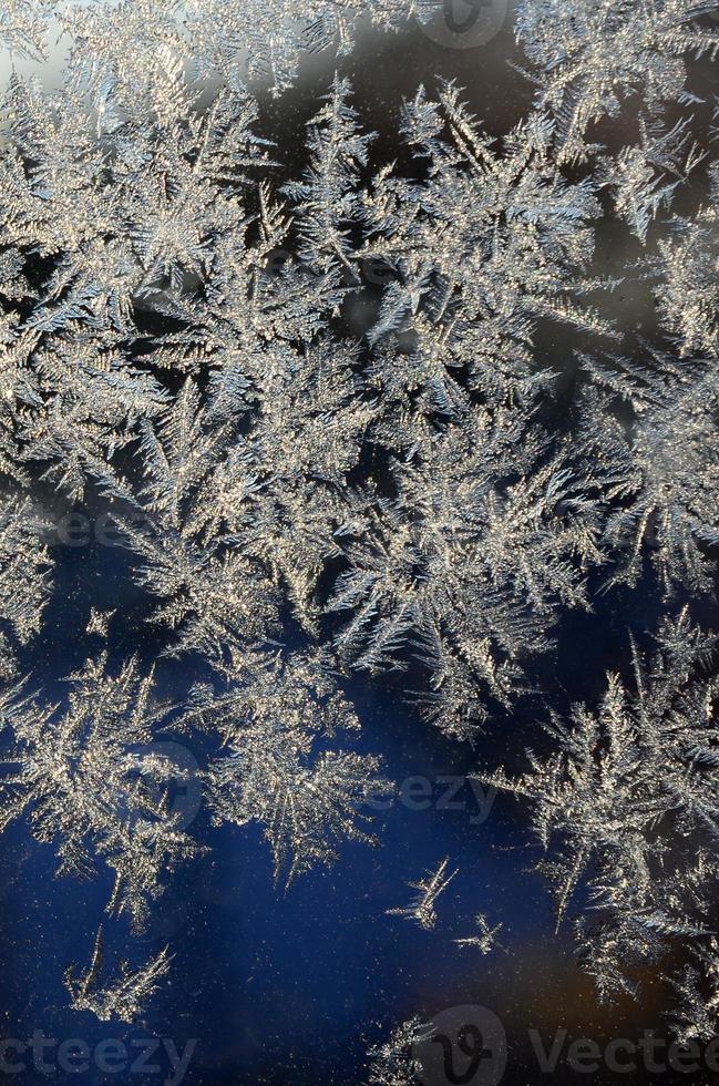 Snowflakes frost rime macro on window glass pane photo
