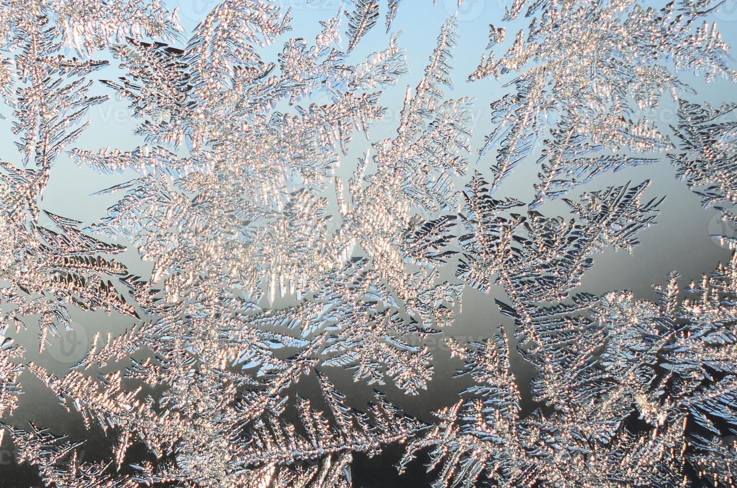 Snowflakes frost rime macro on window glass pane photo