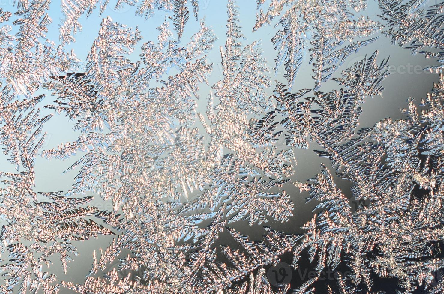Snowflakes frost rime macro on window glass pane photo
