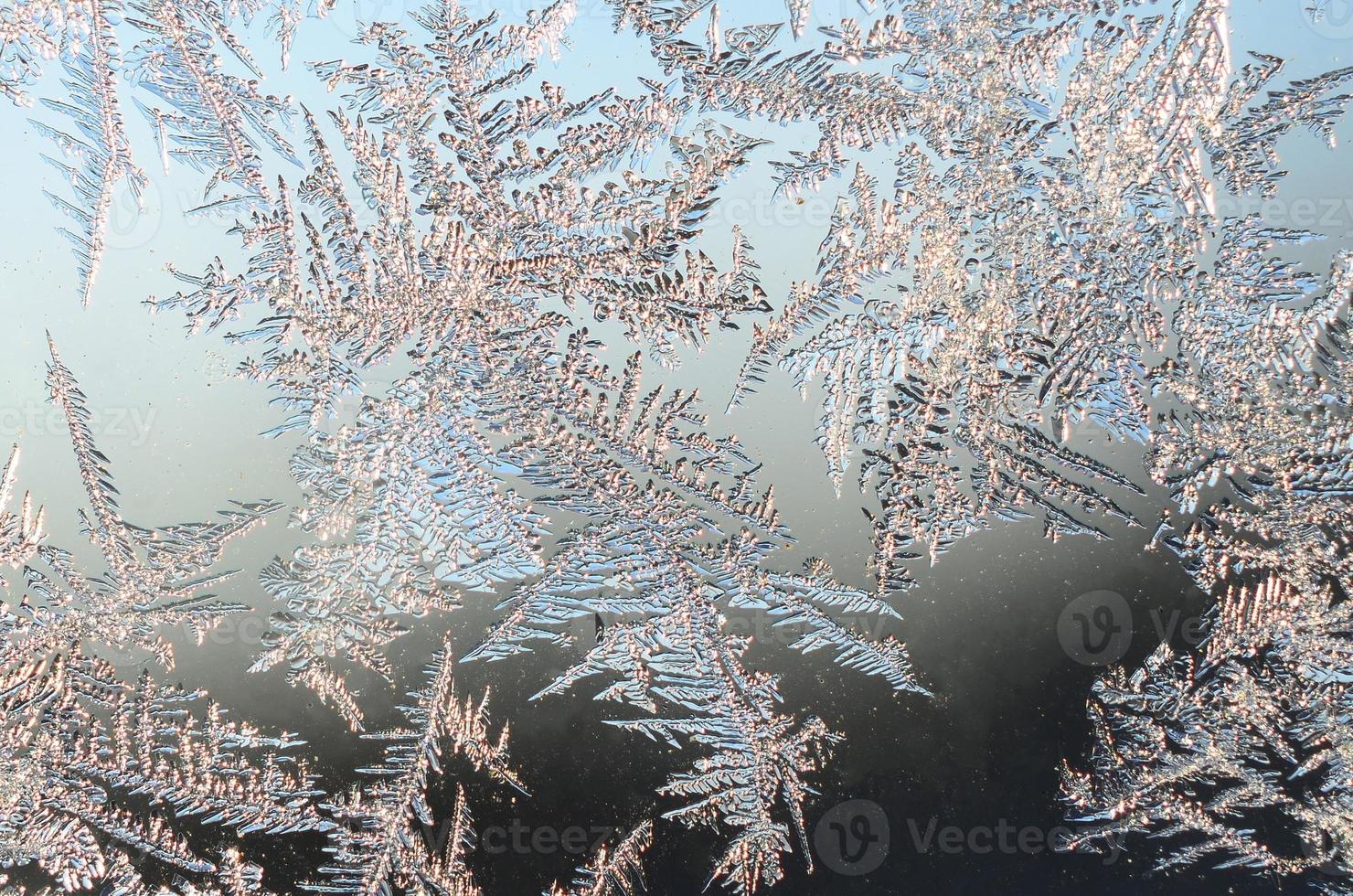 Snowflakes frost rime macro on window glass pane photo