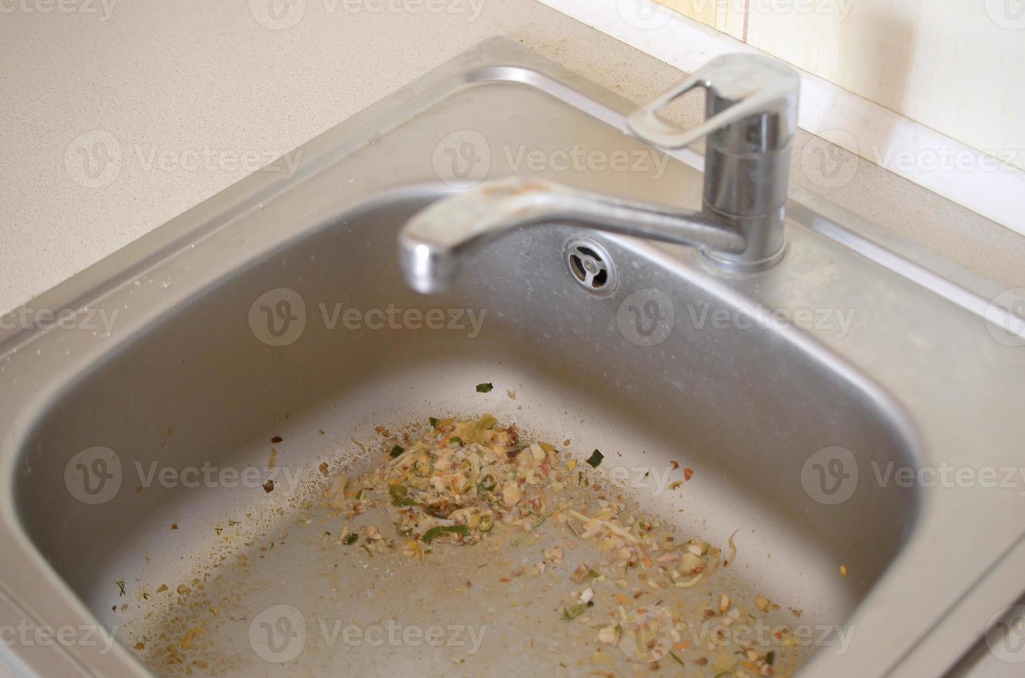 Close up on dirty clogging kitchen sink drain with food particles photo