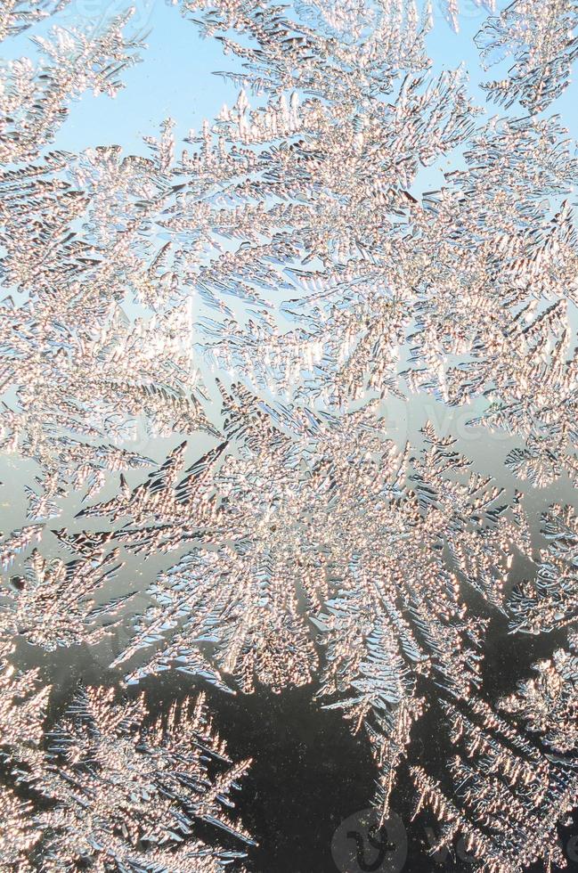 Snowflakes frost rime macro on window glass pane photo