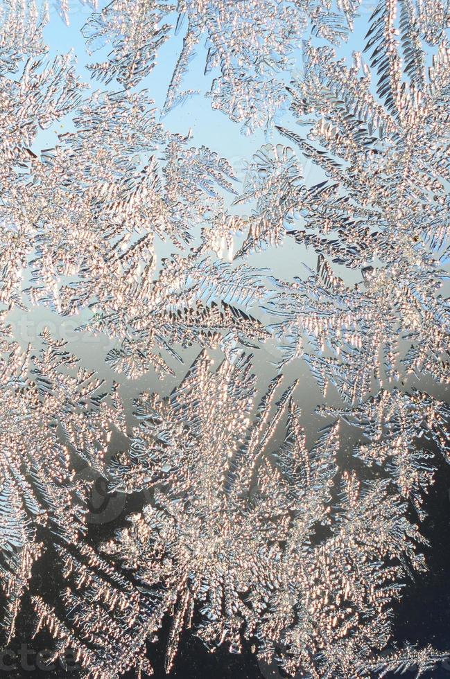 Snowflakes frost rime macro on window glass pane photo