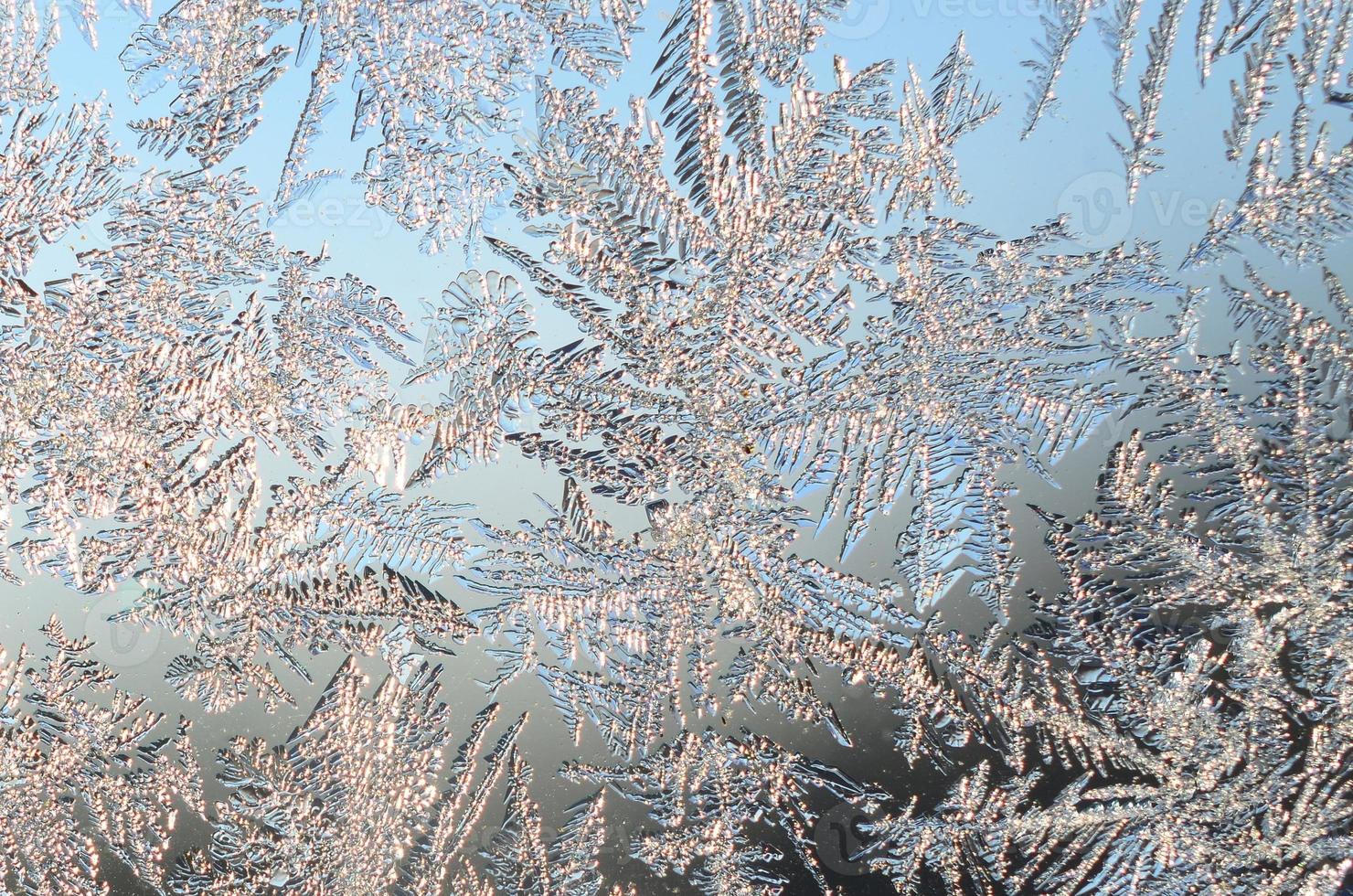 Snowflakes frost rime macro on window glass pane photo