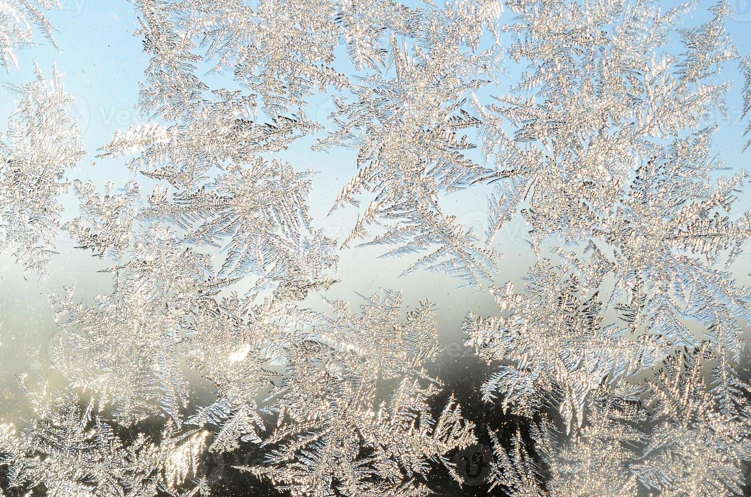 Snowflakes frost rime macro on window glass pane photo