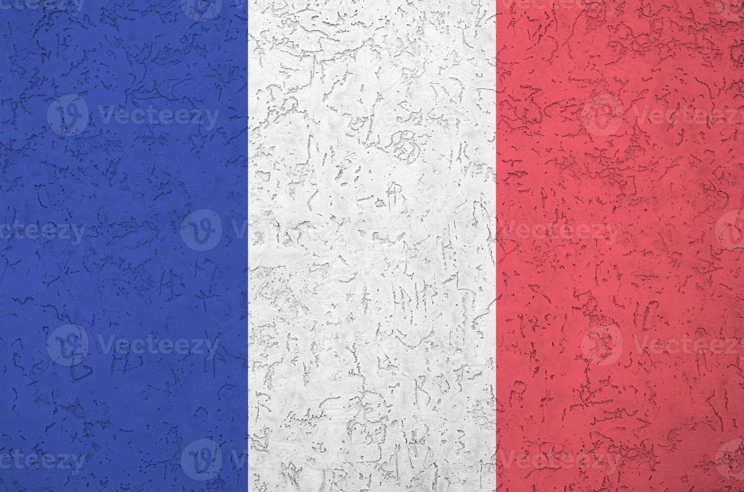 France flag depicted in bright paint colors on old relief plastering wall. Textured banner on rough background photo