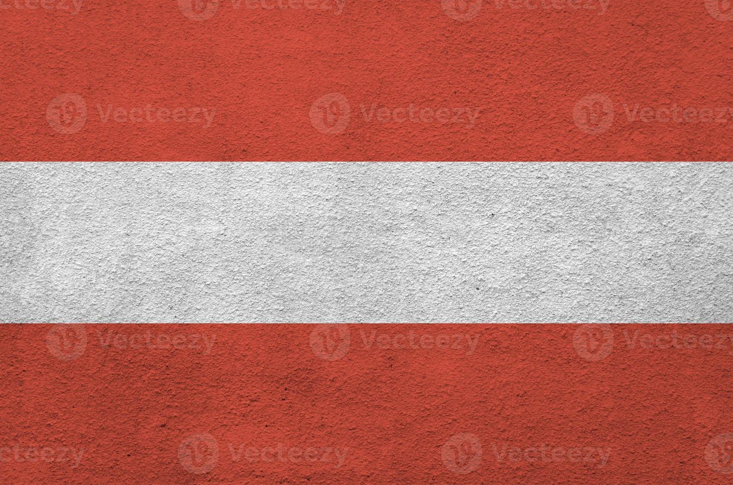 Austria flag depicted in bright paint colors on old relief plastering wall. Textured banner on rough background photo