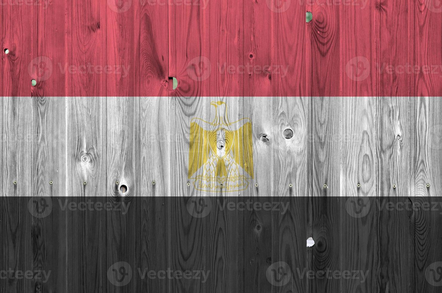 Egypt flag depicted in bright paint colors on old wooden wall. Textured banner on rough background photo