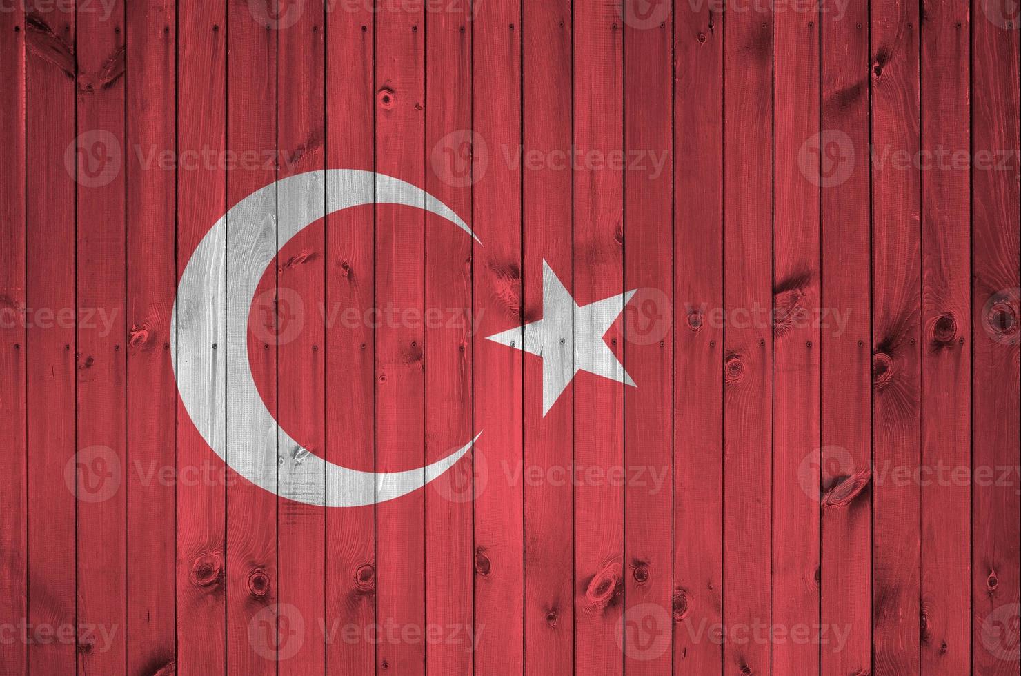 Turkey flag depicted in bright paint colors on old wooden wall. Textured banner on rough background photo