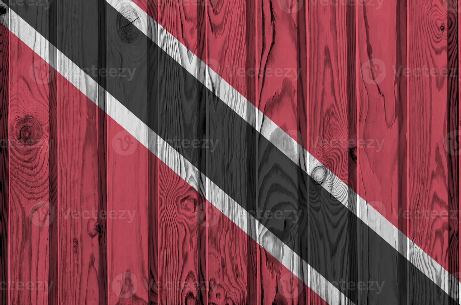 Trinidad and Tobago flag depicted in bright paint colors on old wooden wall. Textured banner on rough background photo