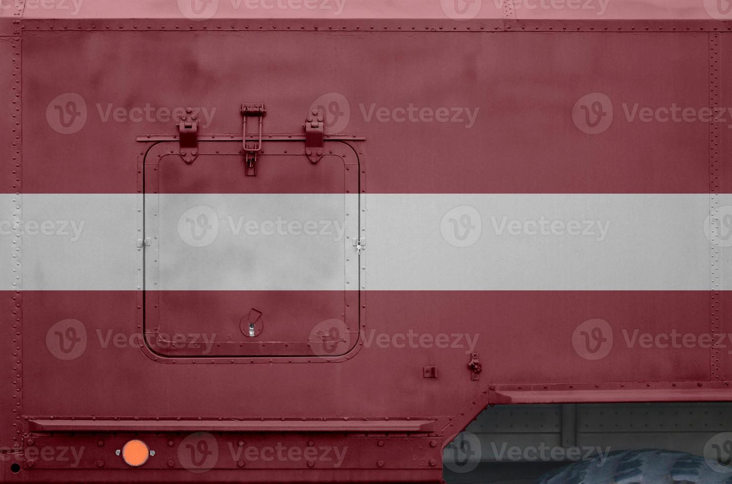 Latvia flag depicted on side part of military armored truck closeup. Army forces conceptual background photo