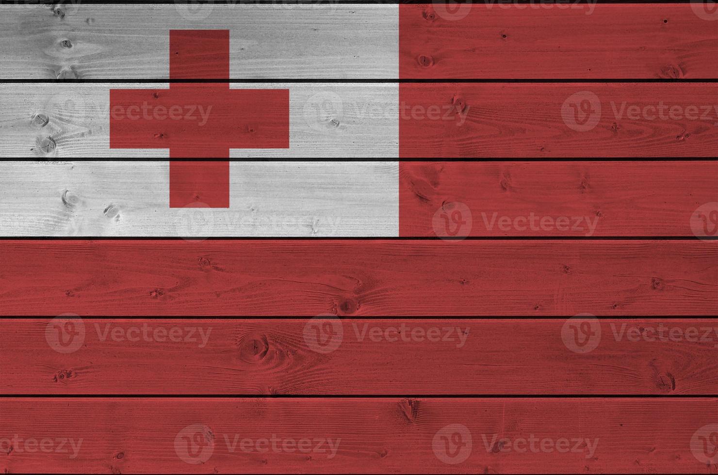 Tonga flag depicted in bright paint colors on old wooden wall. Textured banner on rough background photo