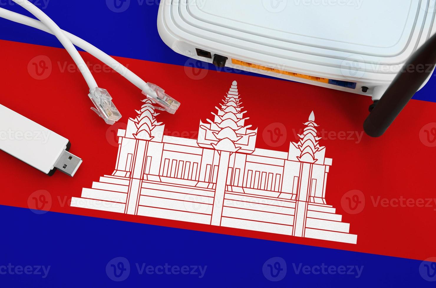 Cambodia flag depicted on table with internet rj45 cable, wireless usb wifi adapter and router. Internet connection concept photo