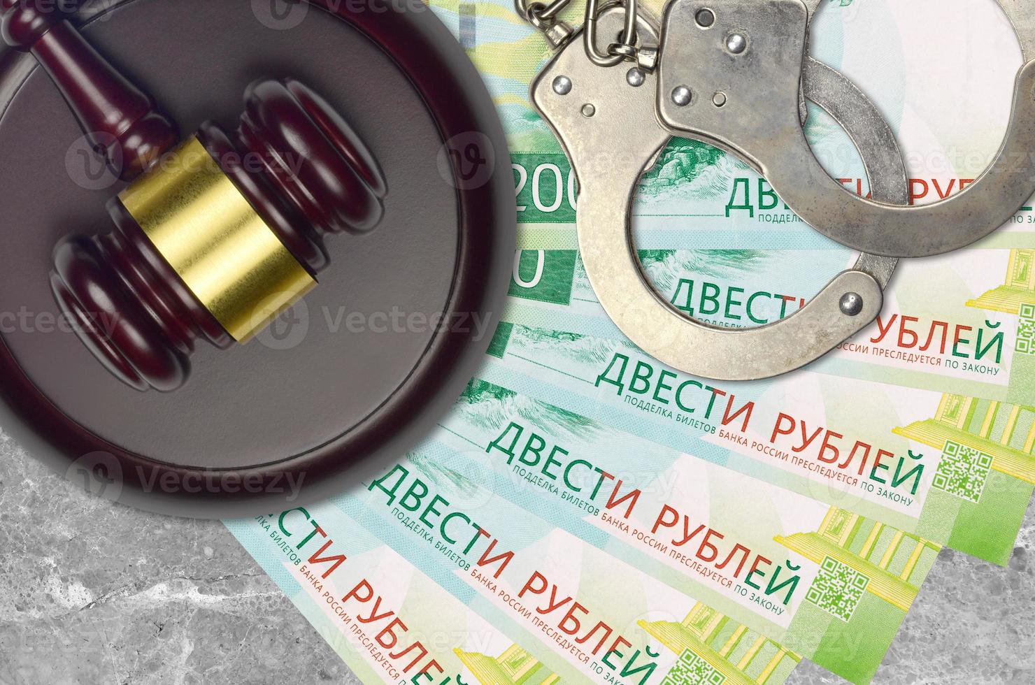 200 russian rubles bills and judge hammer with police handcuffs on court desk. Concept of judicial trial or bribery. Tax avoidance photo
