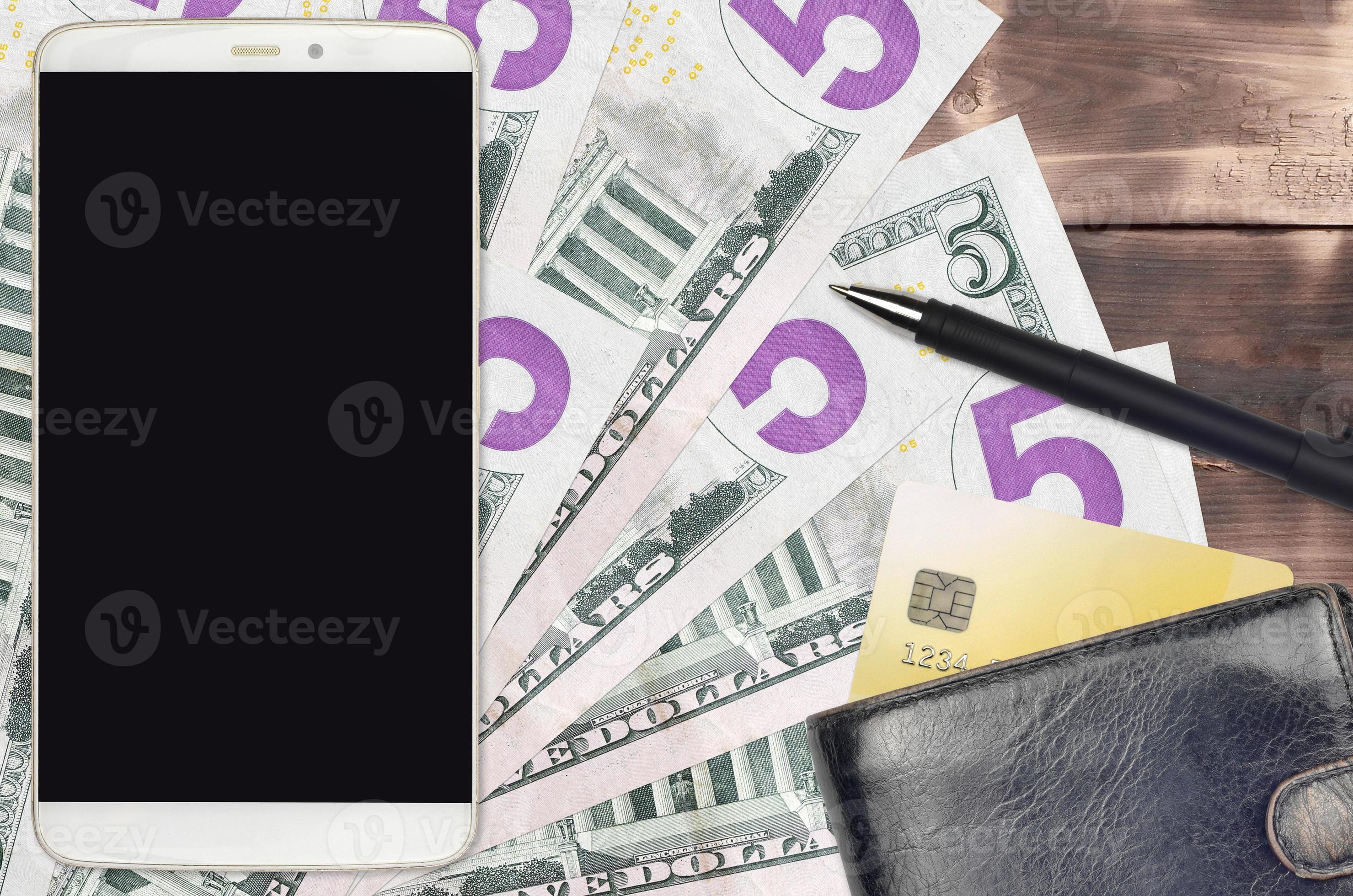 Billetes de 5 dólares estadounidenses y teléfono inteligente con monedero y tarjeta de crédito