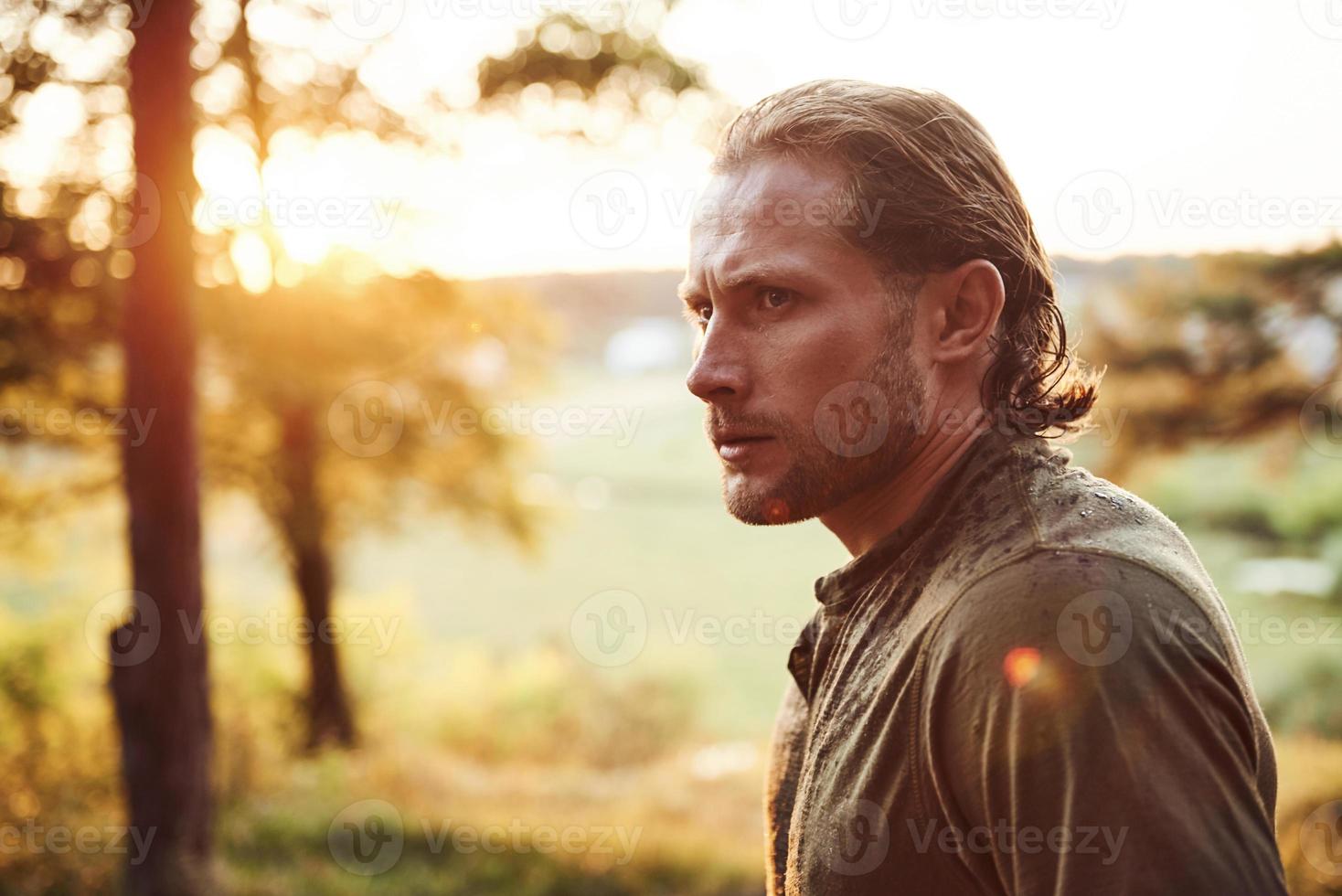 Beautiful man in the forest. Good weather. Beautiful orange colored sunlight photo