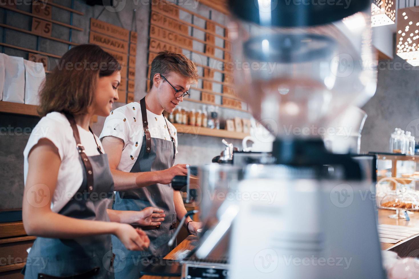 Working together. Two young cafe employees indoors. Conception of business and service photo