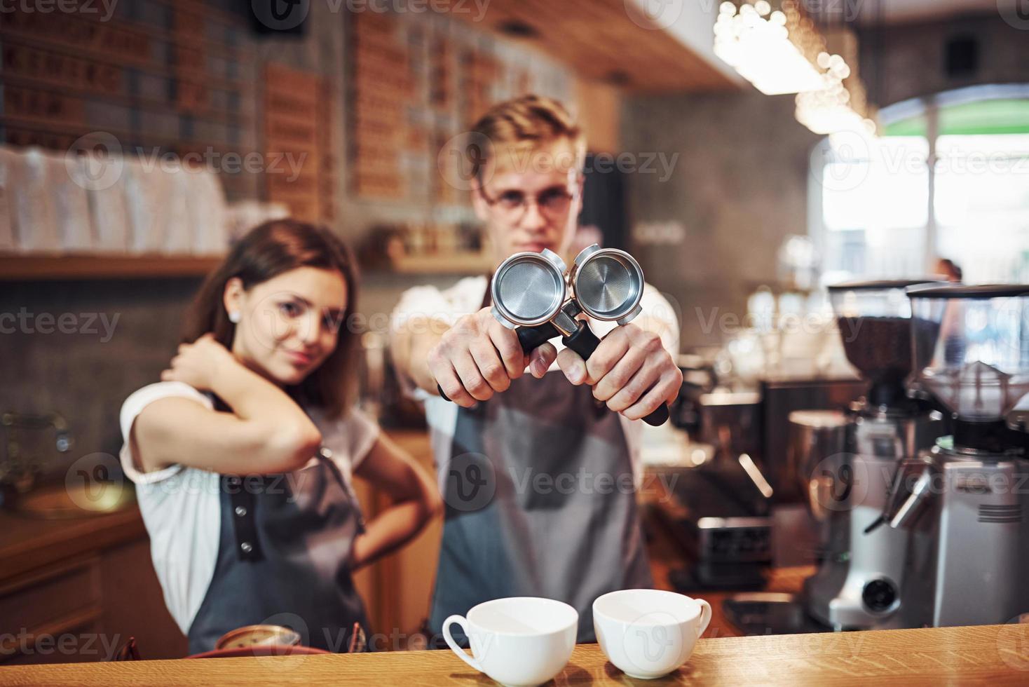 Front view. Two young cafe workers indoors. Conception of business and service photo