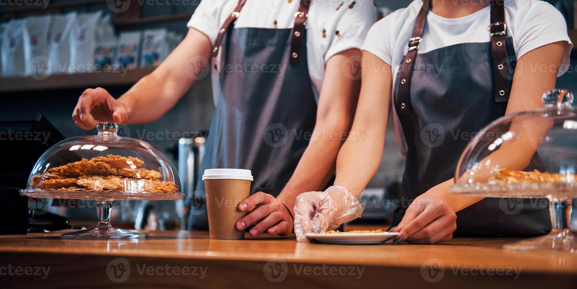 Two young cafe workers indoors. Conception of business and service photo