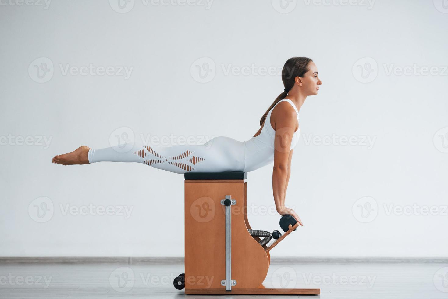 Exercise for the spine. Confident young sporty woman with slim body type in the healthy center photo