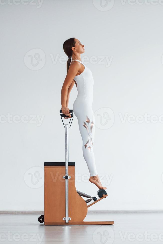 Exercise for the spine. Confident young sporty woman with slim body type in the healthy center photo