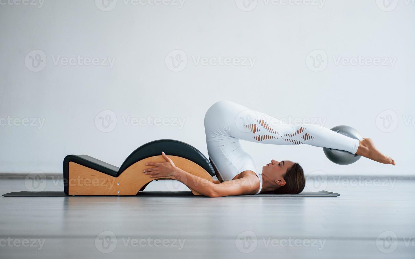 se necesita buena resistencia. joven deportista segura de sí misma con un tipo de cuerpo delgado en el centro saludable haciendo ejercicios usando equipo especial foto