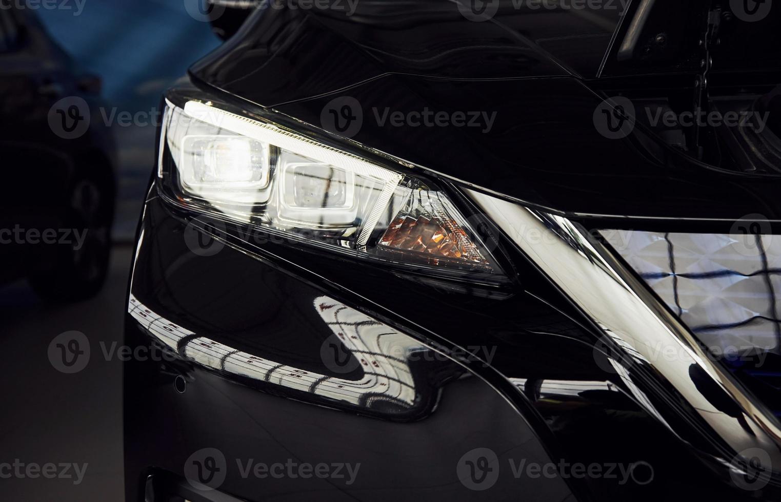 Particle view of brand new modern electric car. Cropped photo