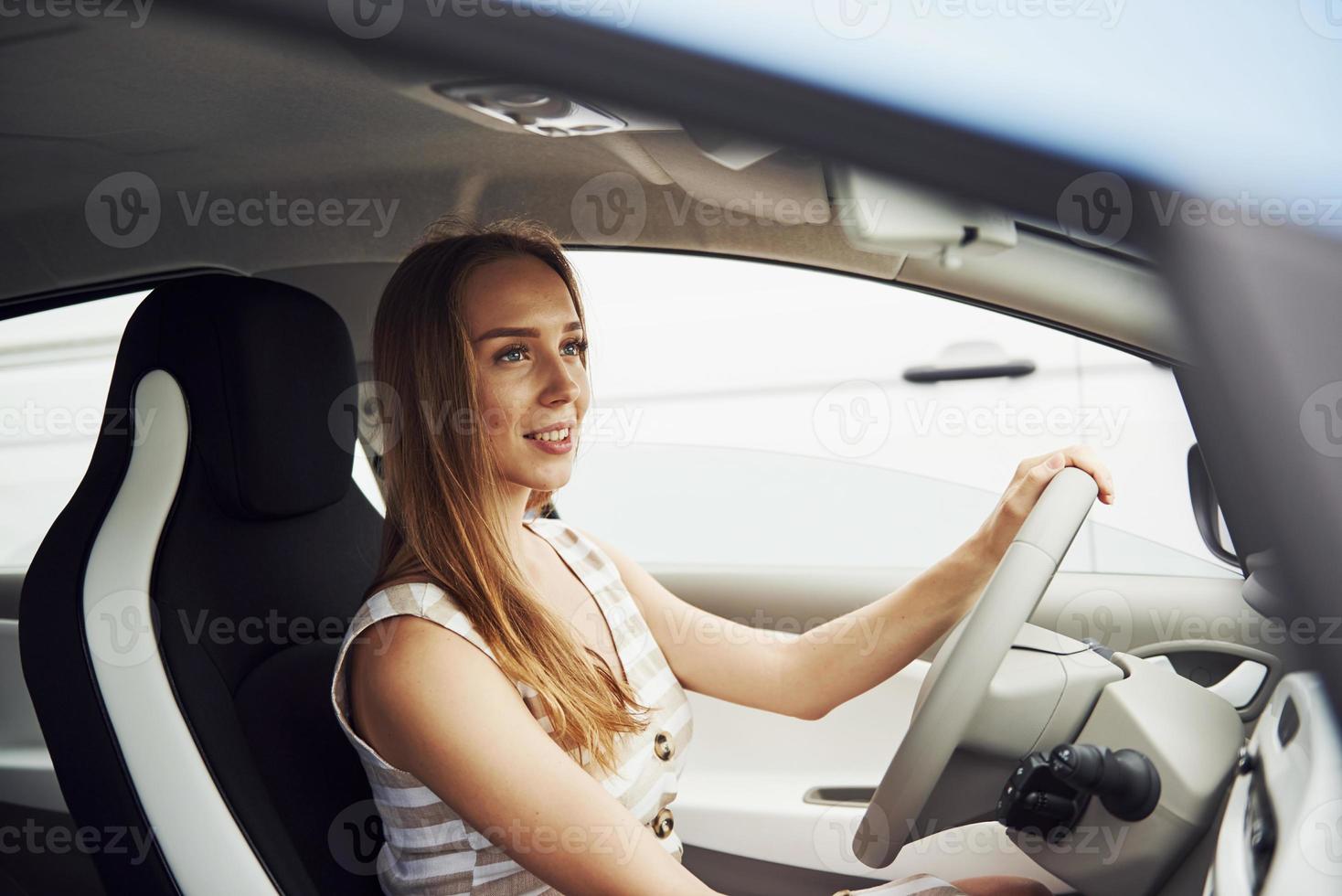 Female driver inside of modern automobile. Testing brand new car photo