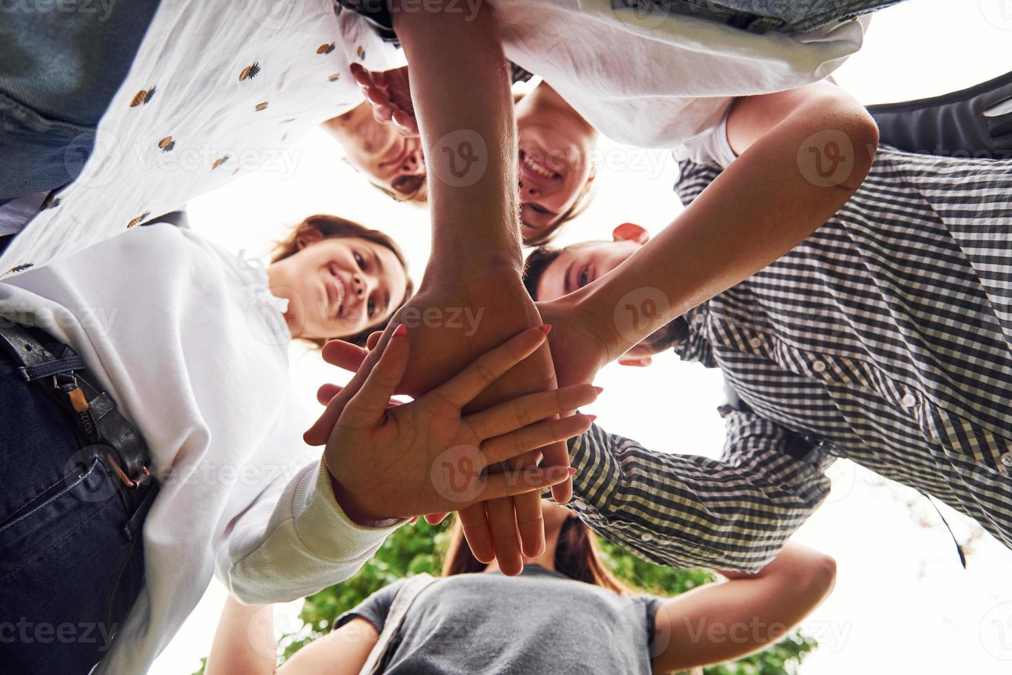 Close up view of hands of the young team of successful friends outdoors photo