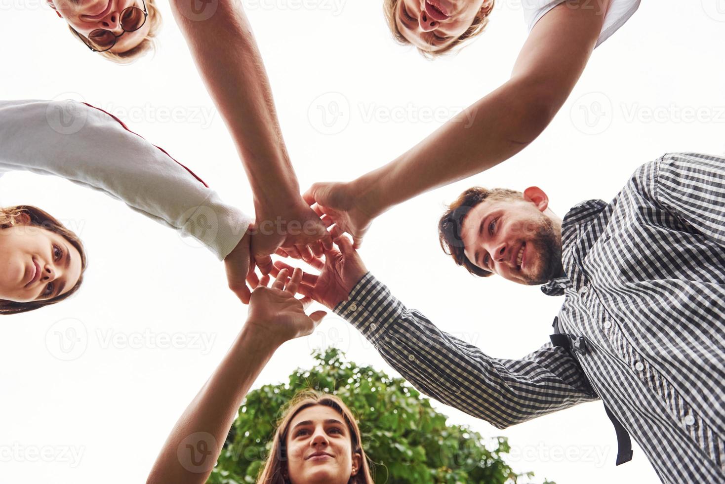 vista de cerca de las manos del joven equipo de amigos exitosos al aire libre foto