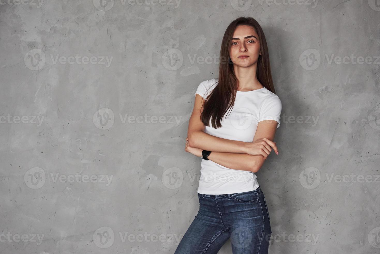 Warm in the room. Young beautiful woman in the studio standing against