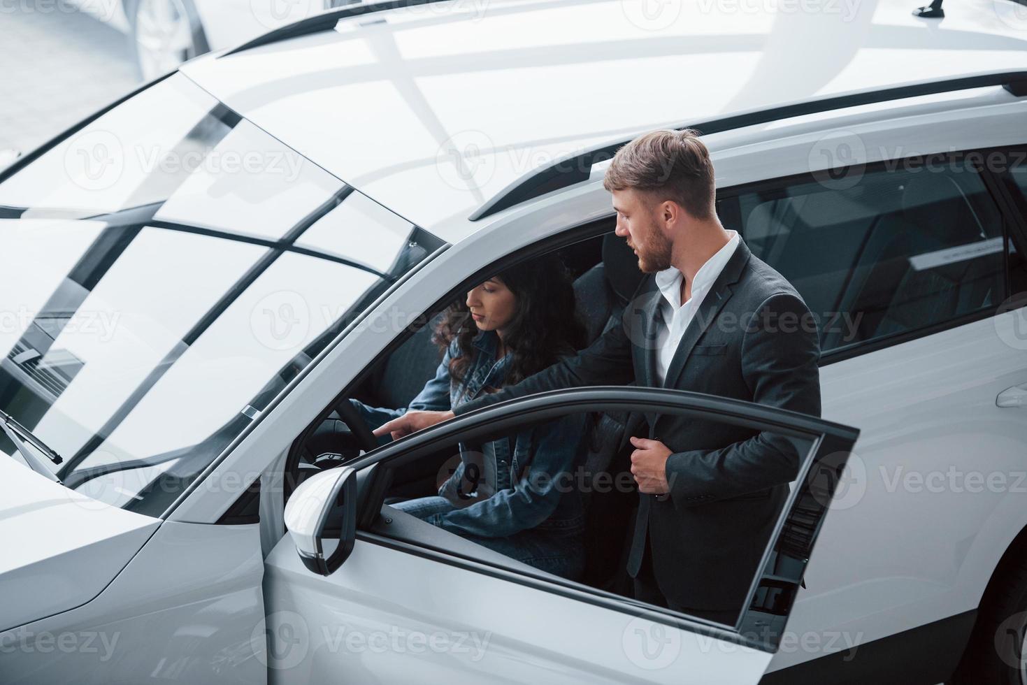 atención a los detalles. Cliente femenino y moderno y elegante hombre de negocios barbudo en el salón del automóvil foto