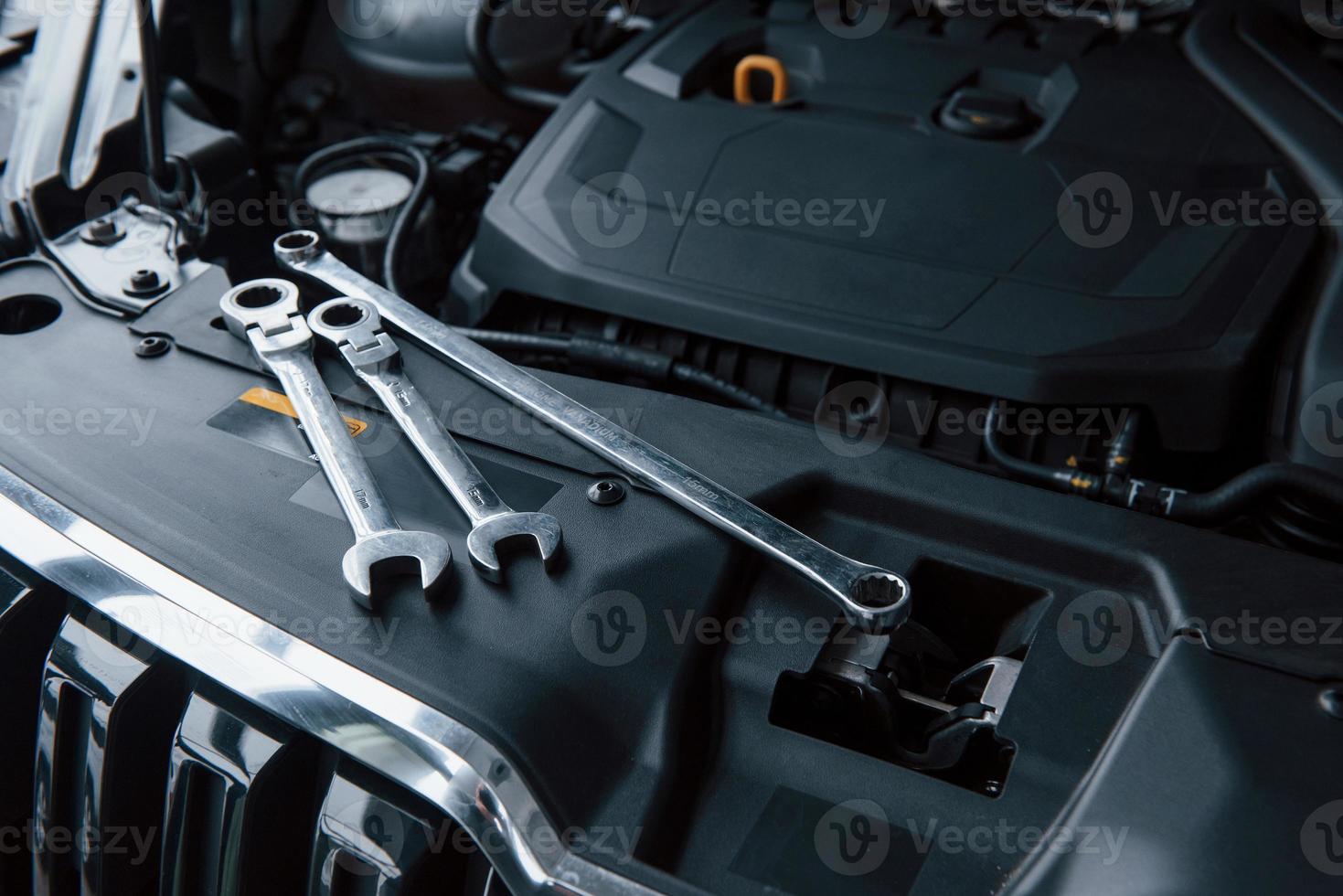 Top view. Repair tools lying down on the engine of automobile under the hood photo